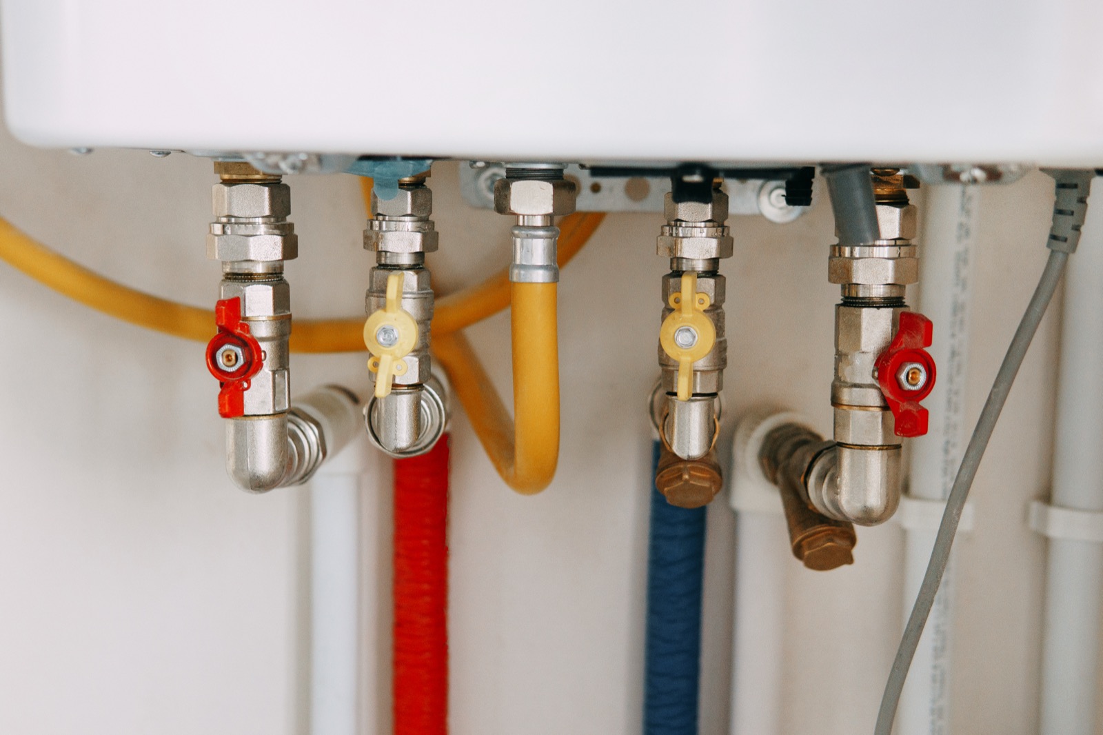 Close-up of water heater pipes and valves where hard-water scale builds up