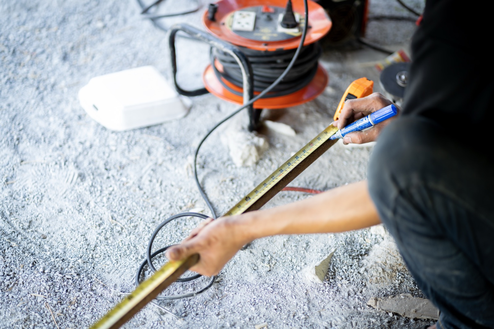 Worker measuring and marking a window opening for repair
