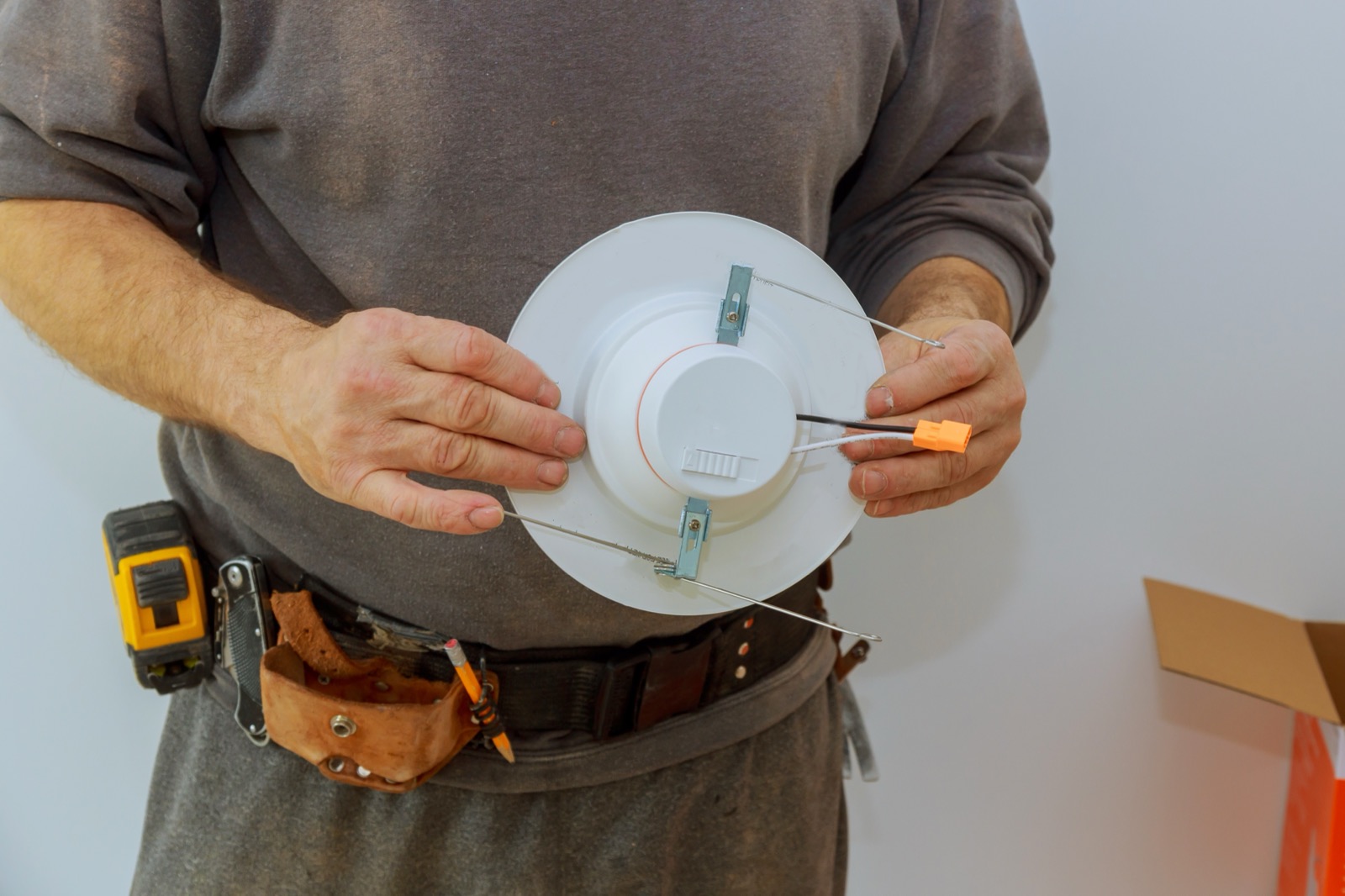 Technician installing a fixture on a room ceiling