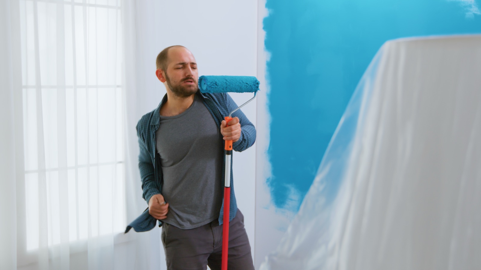 Painter rolling fresh paint onto an interior wall