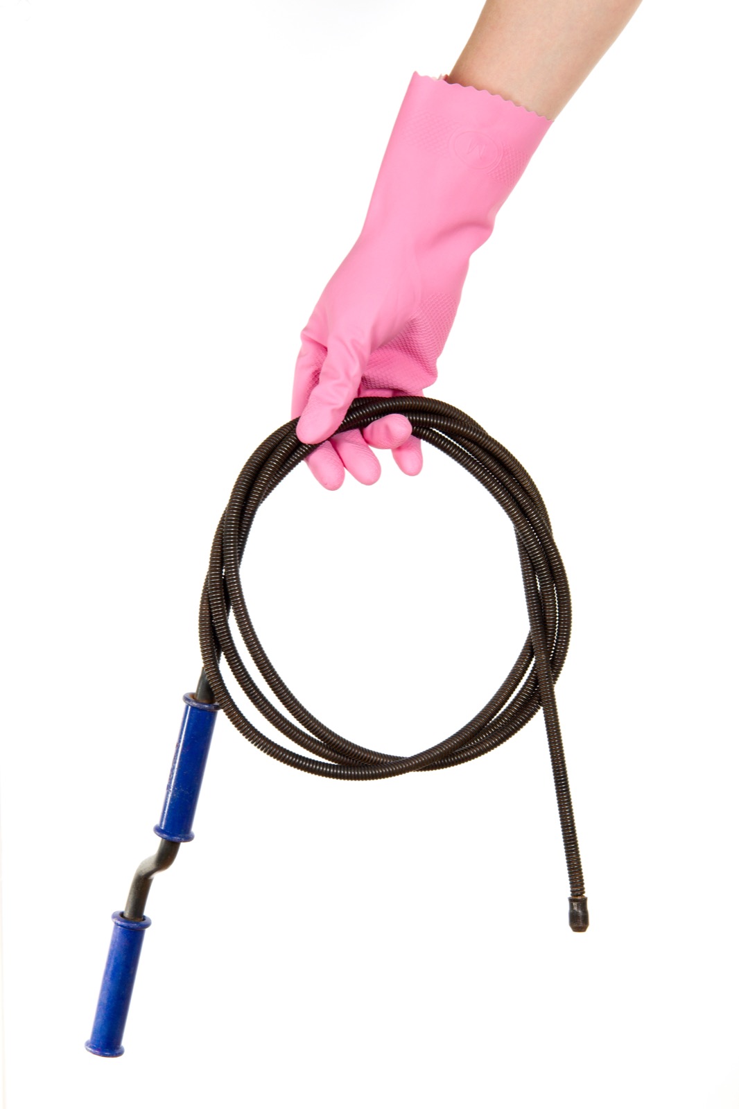 Gloved hand feeding a drain cleaning snake into a household drain