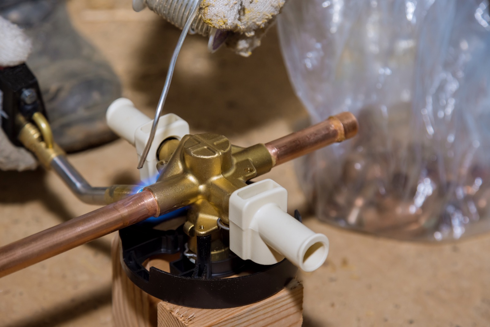 Plumber soldering copper pipe during a repair in an older Terrell home near downtown