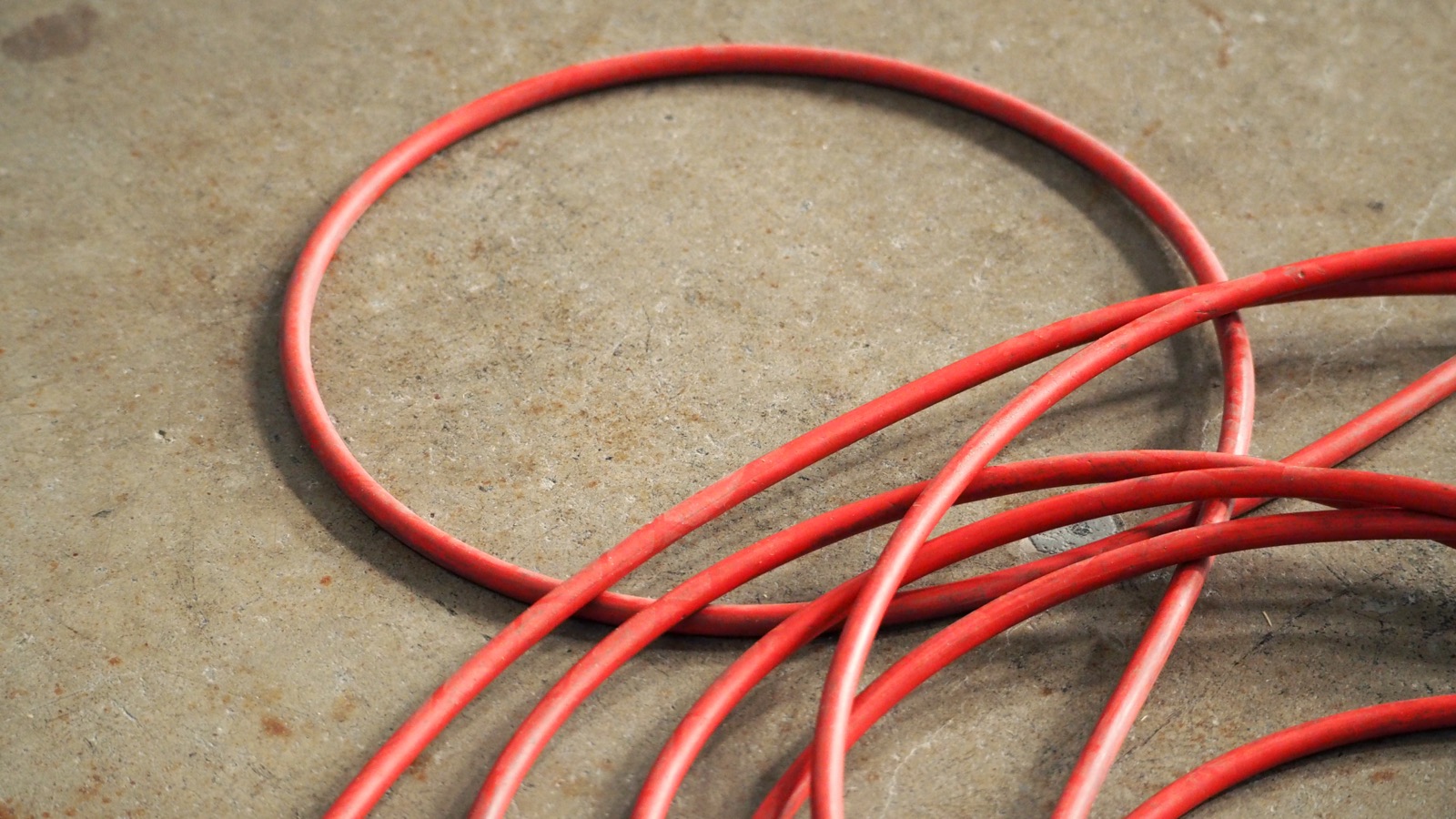 Pressure washer hoses coiled on a concrete driveway