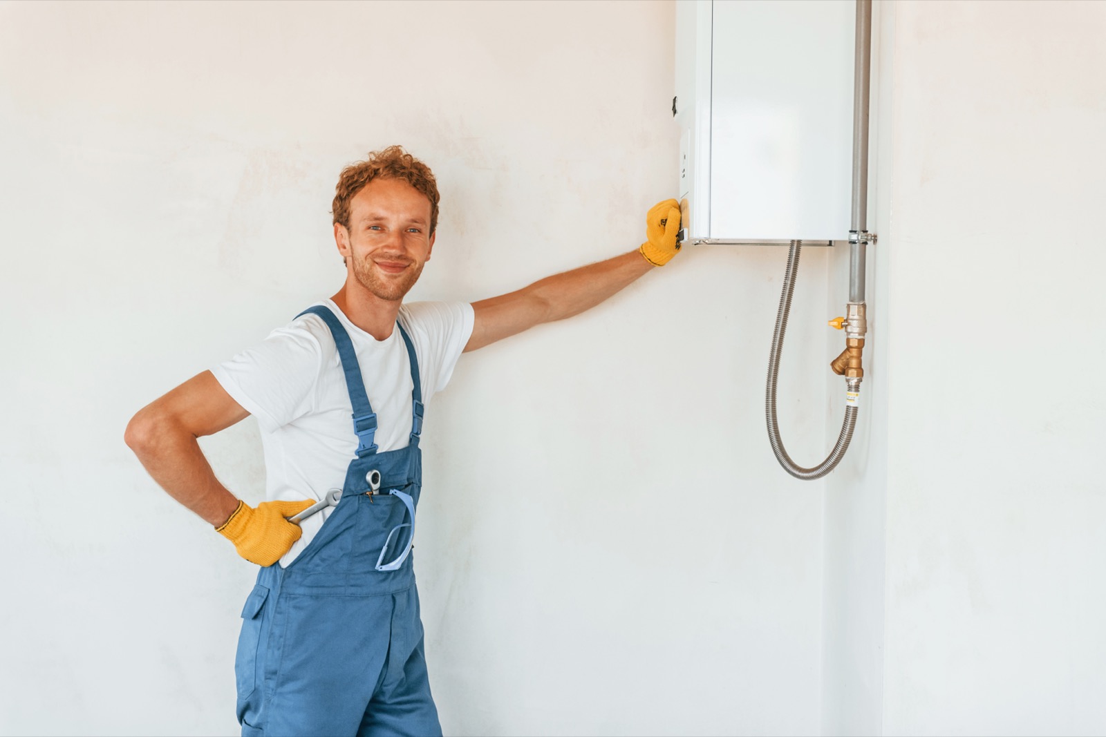 Plumber standing with a newly installed water heater in a Frisco home