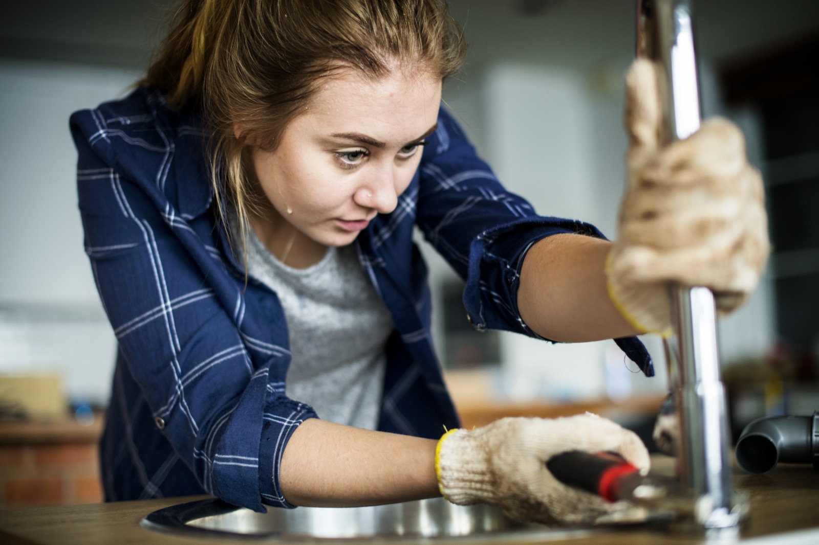 Plumber working on sink plumbing in an Addison home