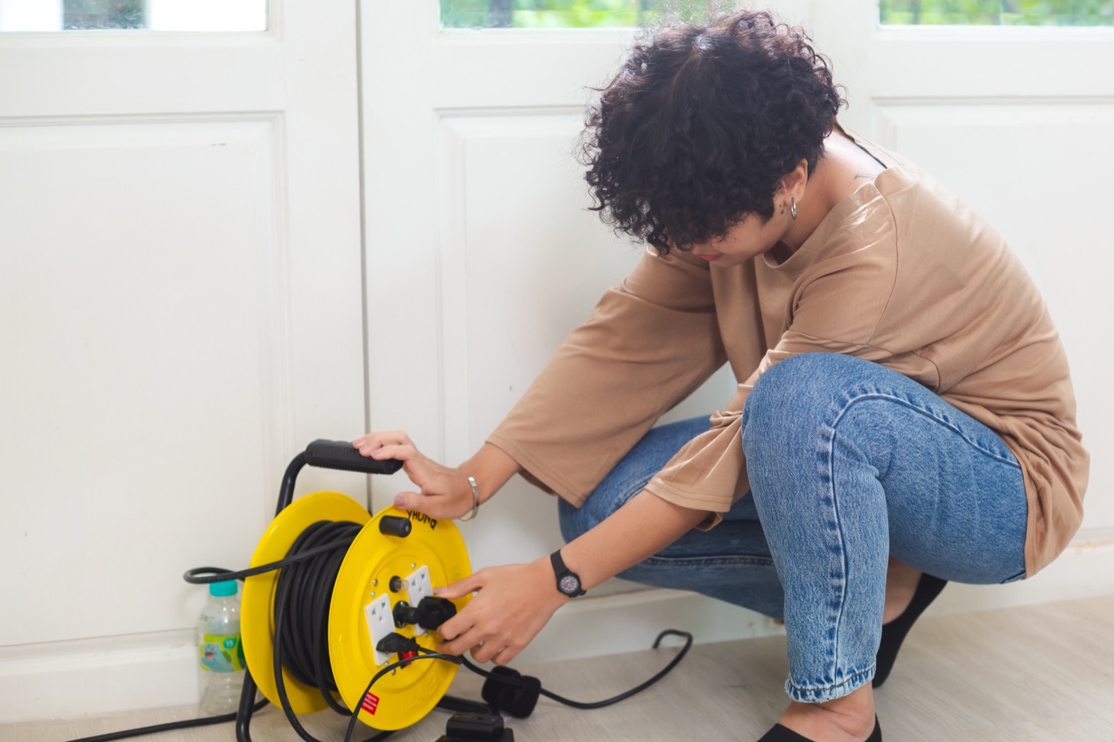 Technician plugging a device into a wall outlet to test it